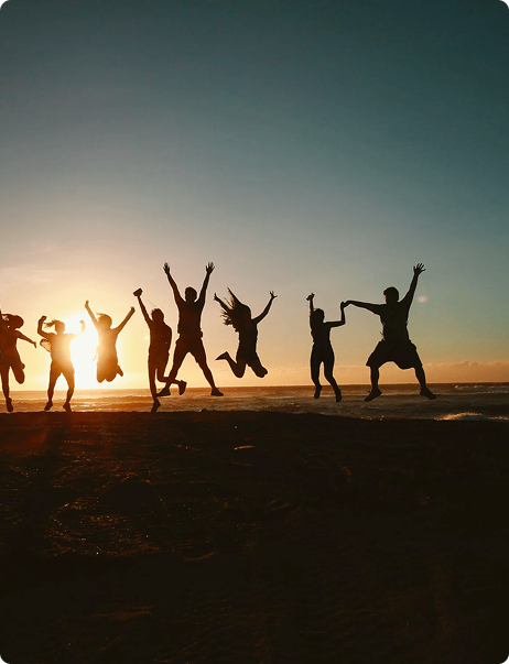 People jumping against a sunset